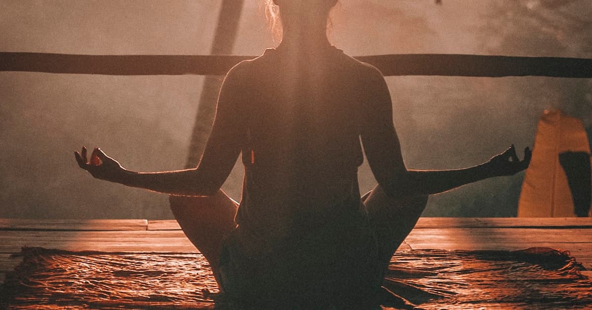 Pencere kenarında, sabah ışığında duran sade bir meditasyon minderi